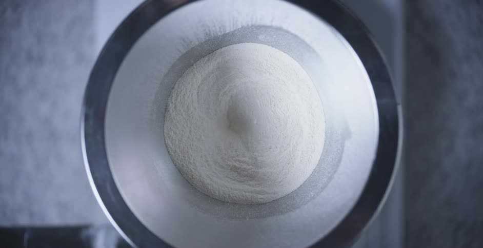 White grainy powder shifts down out of container