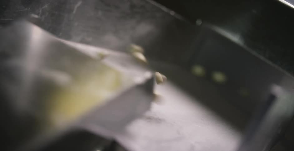 Popcorn kernels going down a shoot in a factory