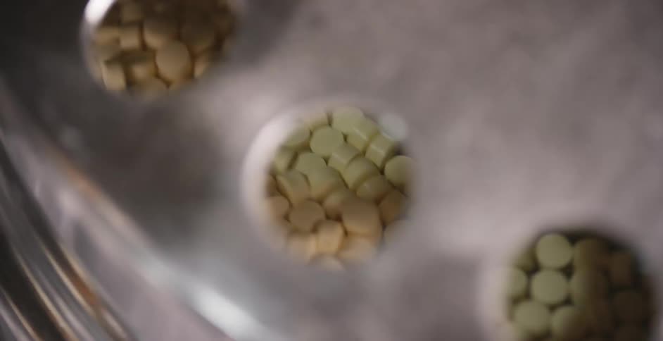 Round medication pills are sorted in a machine
