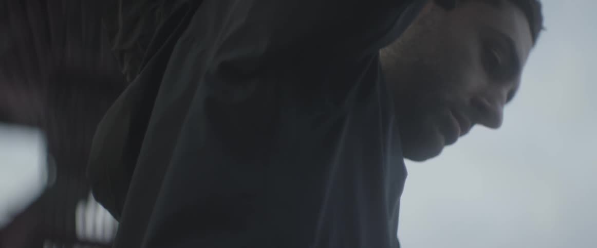 A man is standing and looking down through a window