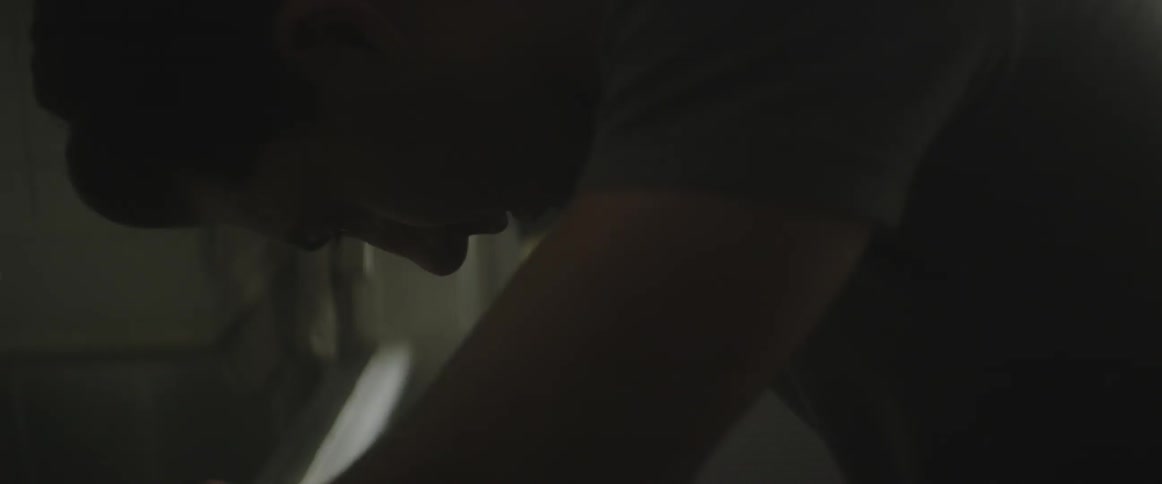 A man leaning over and scratching his nose