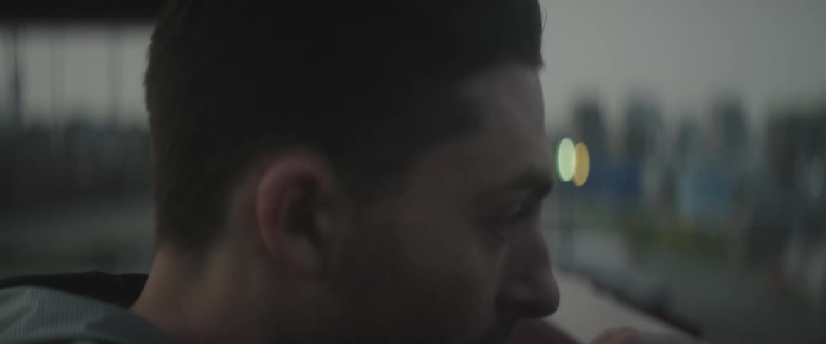 A man looks outside and ducks behind a ledge
