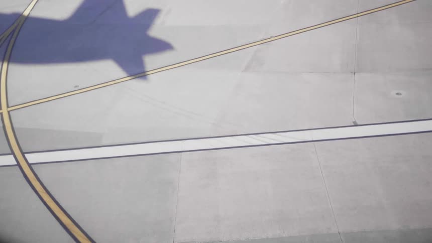 A shadow of an airplane taking off on a runway
