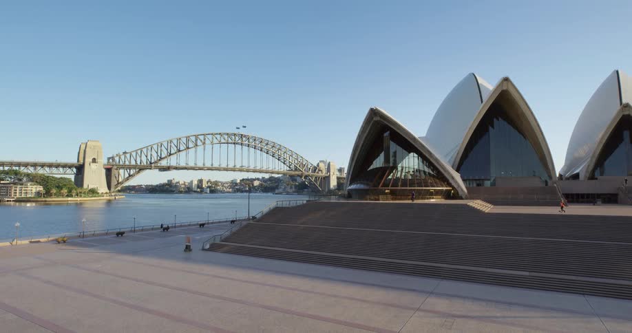 The sydney opera house next to a waterway on a sunny day