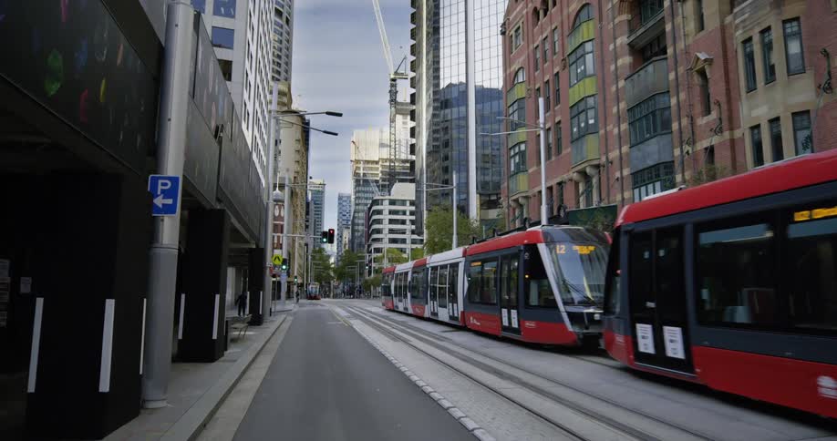 Tram goes along metal tracks in the road