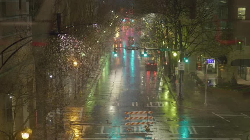 People drive and run in the street on a rainy night