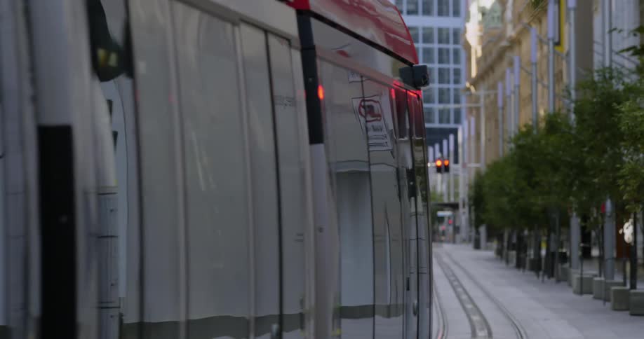 Tram goes along metal tracks in the road