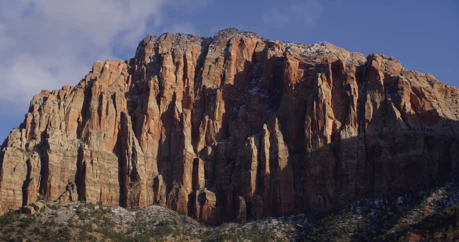 A tall mountain gives shade to the hill below
