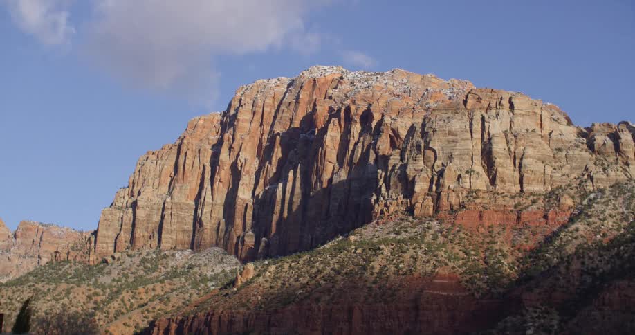 A large rock formation of red rock against a bright blue sky