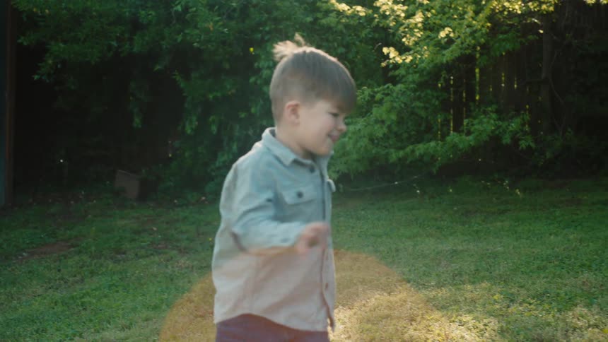 A father and son run around outside and play