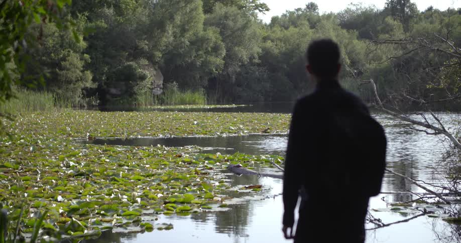 A man stands and looks at the water