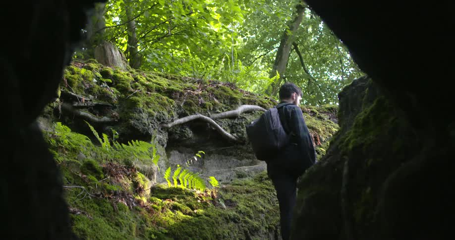 A man climbs up out of the cave