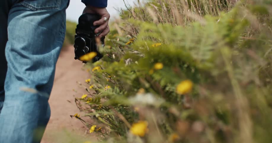 A man is hiking on the trail carrying a camera