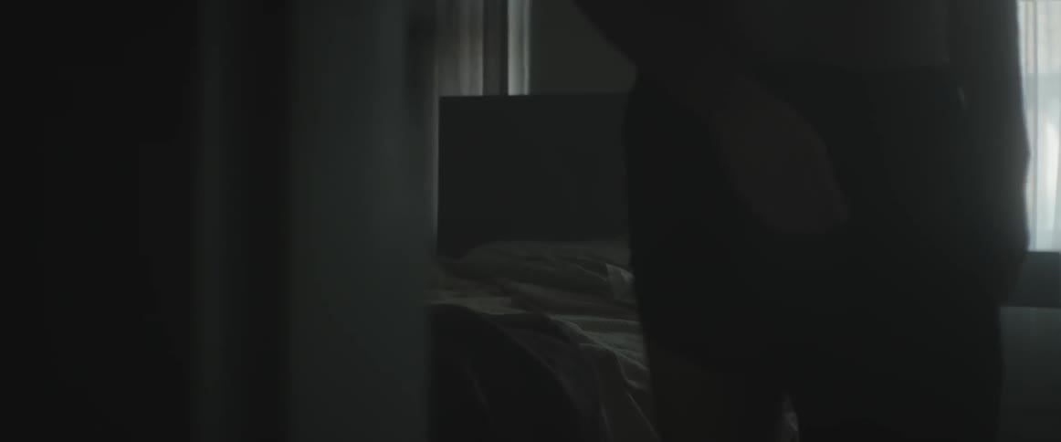 A man getting out of bed and walking toward the camera