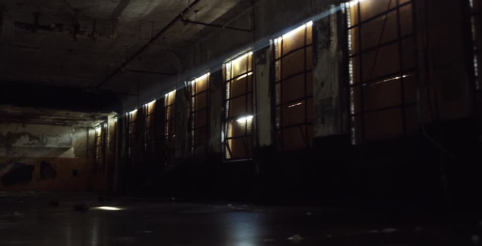 Sunlight creeps in through the cracks of boarded up windows in a dirty room