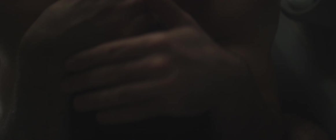 A man has his head pointed down as he puts his hands on the back of his head