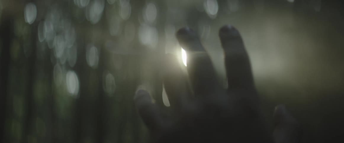 A hand is waving in front of a light in a dark area