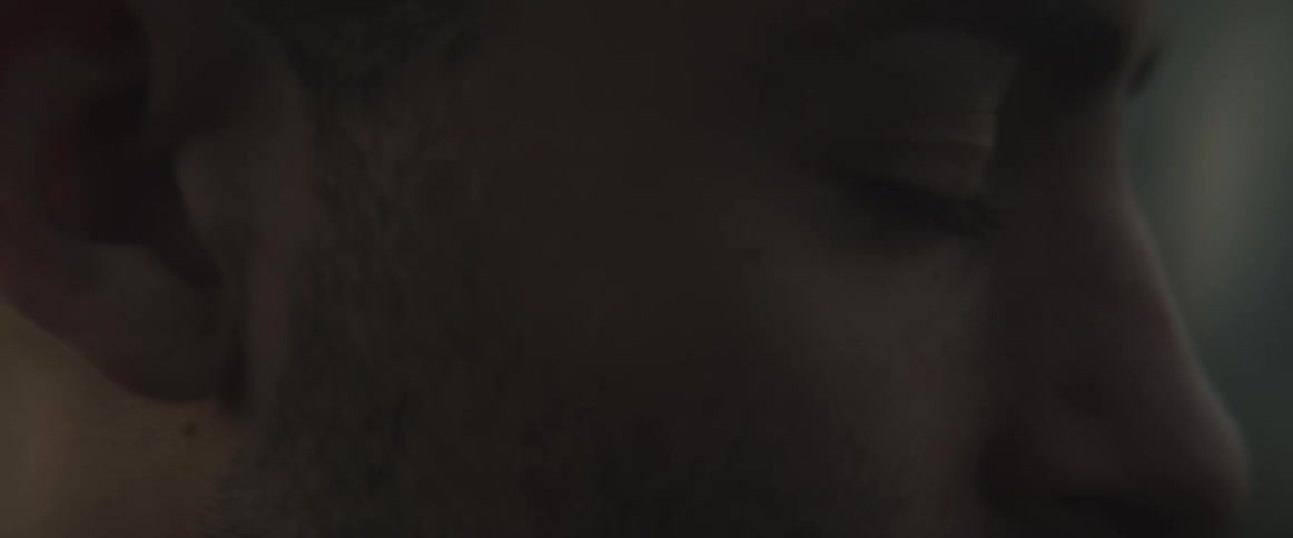 A man is looking around in a dark area