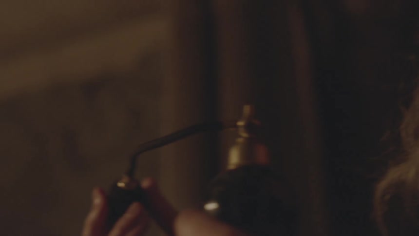 A woman spritzes perfume on herself