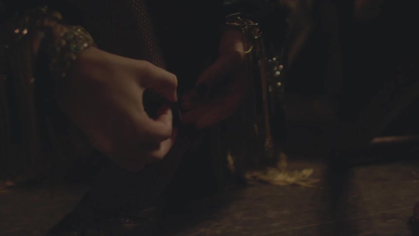 A woman buckling the strap of her shoe