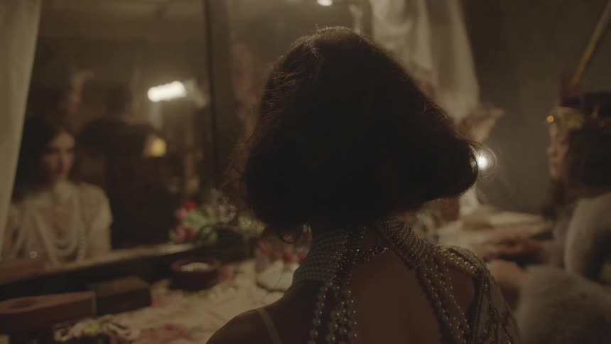 Dressed up women looking into a mirror in a dressing room