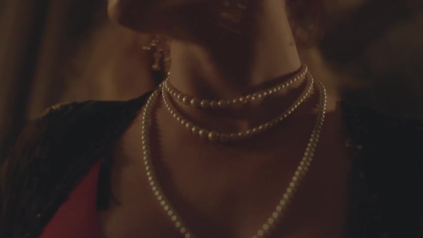 A woman wearing elaborate jewelry and costume turning her head