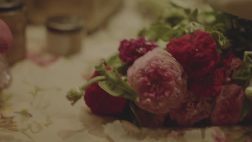 A gloved hand running over a bouquet of flowers
