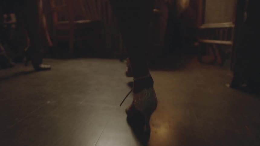 A woman in high heels walks by other women in high heels
