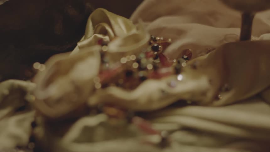 A woman sets down a pink necklace