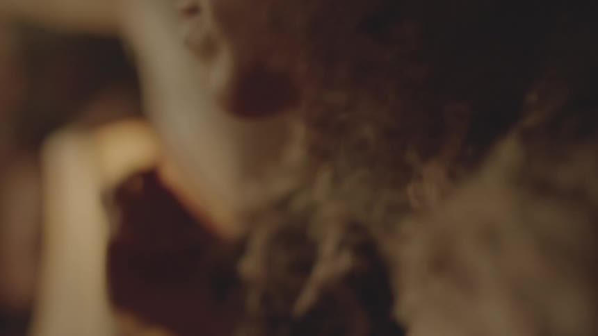 A woman is touching her lips with her hand then brushes her hair