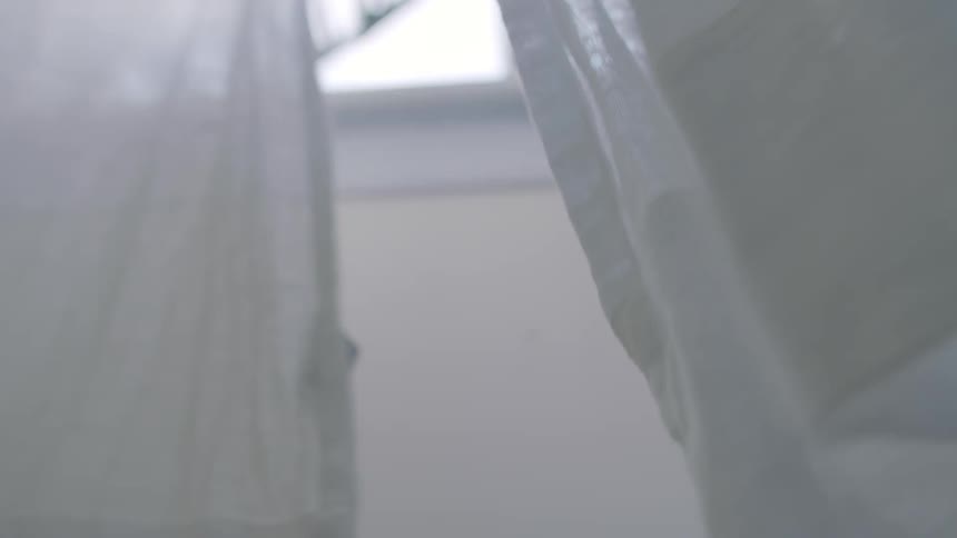 Thin white curtains blowing in the breeze