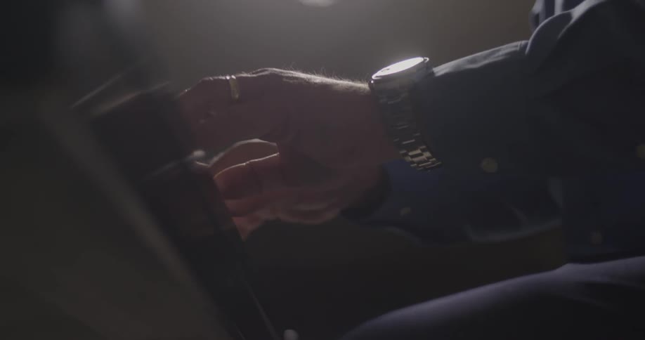 A man wearing a watch plays the piano