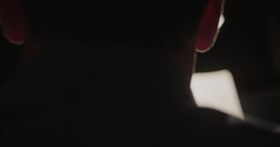 A light shines in front of a man's face