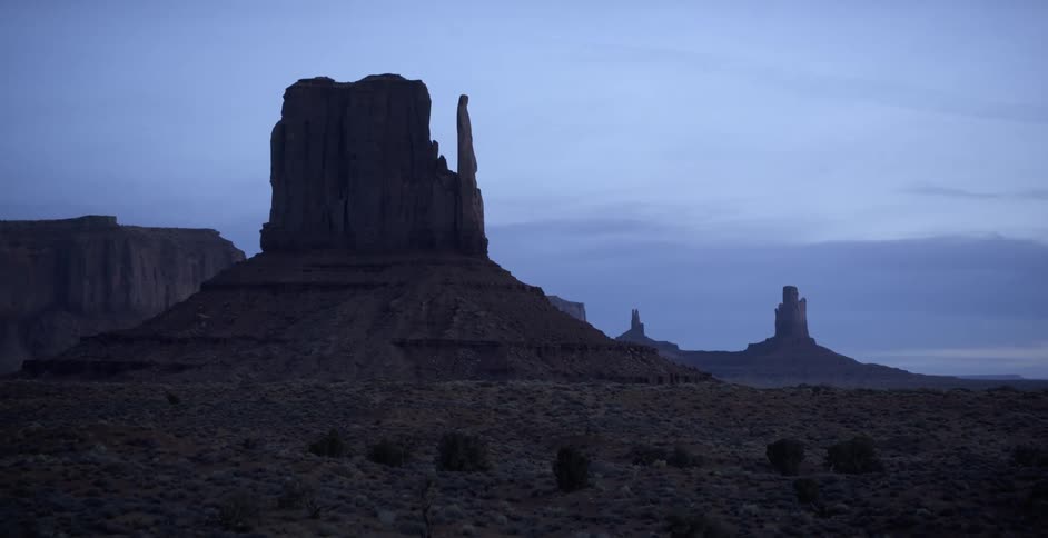 Rock formations sit in a large desert valley
