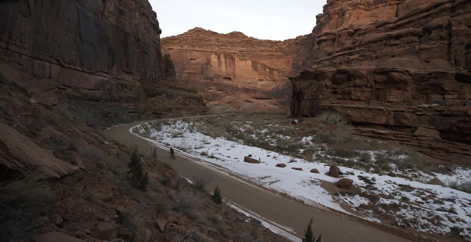 A person is riding a bike through a deep canyon