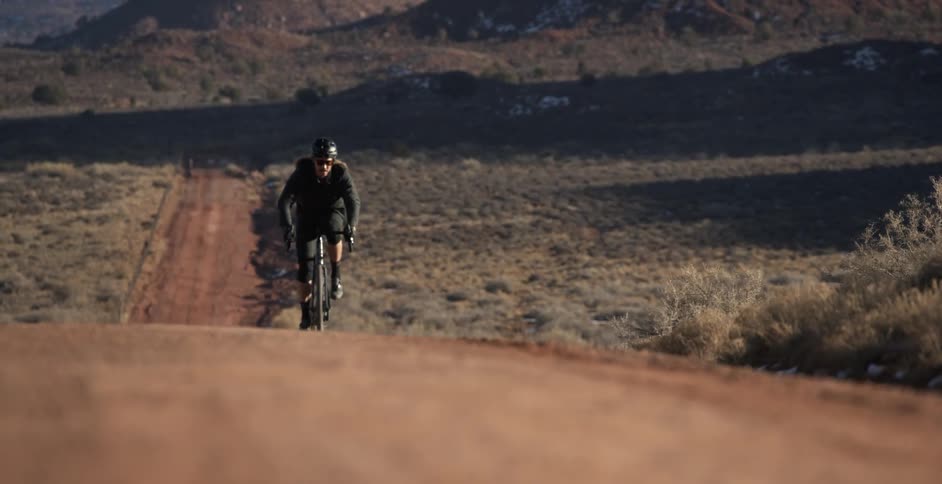 Male cyclist rides a bike uphill on a dirt road