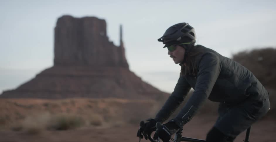 Male cyclist rides a bike on a road through desert