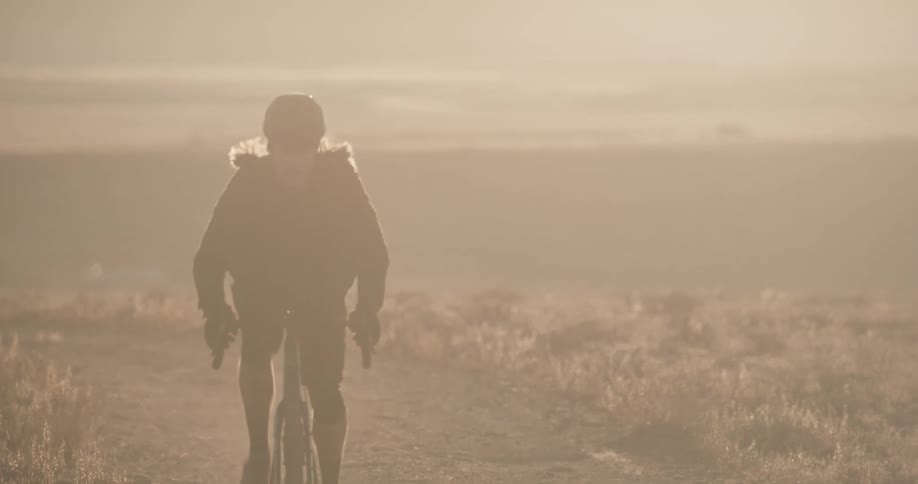 Man rides a bike on a dirt road