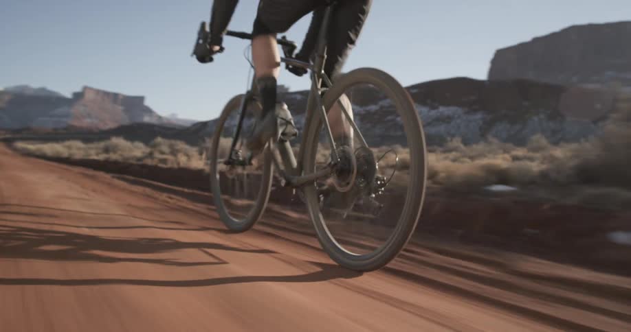 Male cyclist rides along the dirt road
