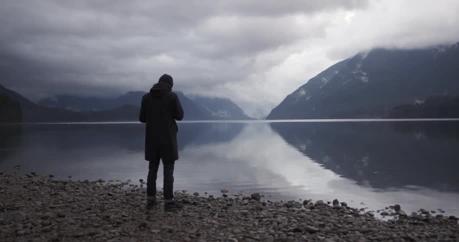 Man stands by the lakeside