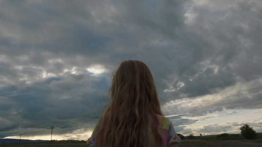 A young girl stands outside and looks around