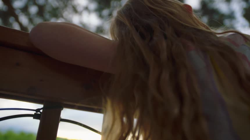 The girl sits on the fence