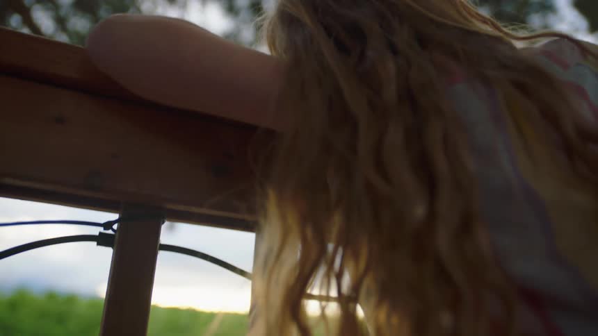 The girl sits on the fence
