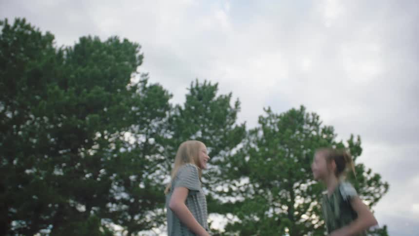 A girls jump together on a trampoline