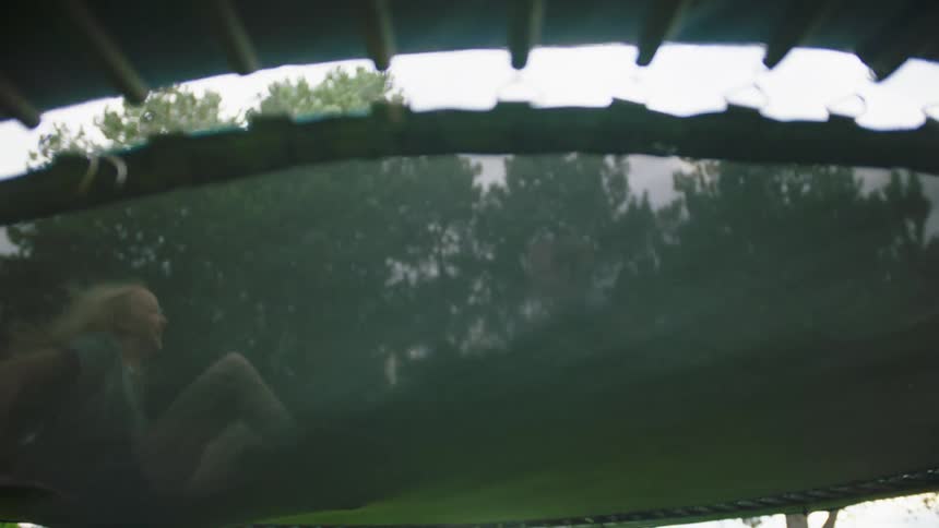 Two girls jump on a trampoline