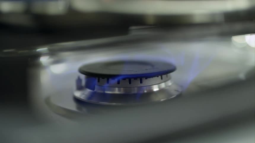 A gas burner on a stove ignites
