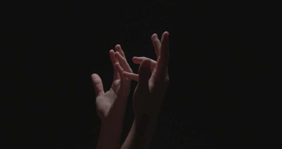 Hands reaching upward with a black background