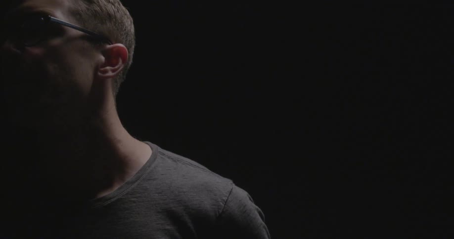 A man in a dark shirt turns his head