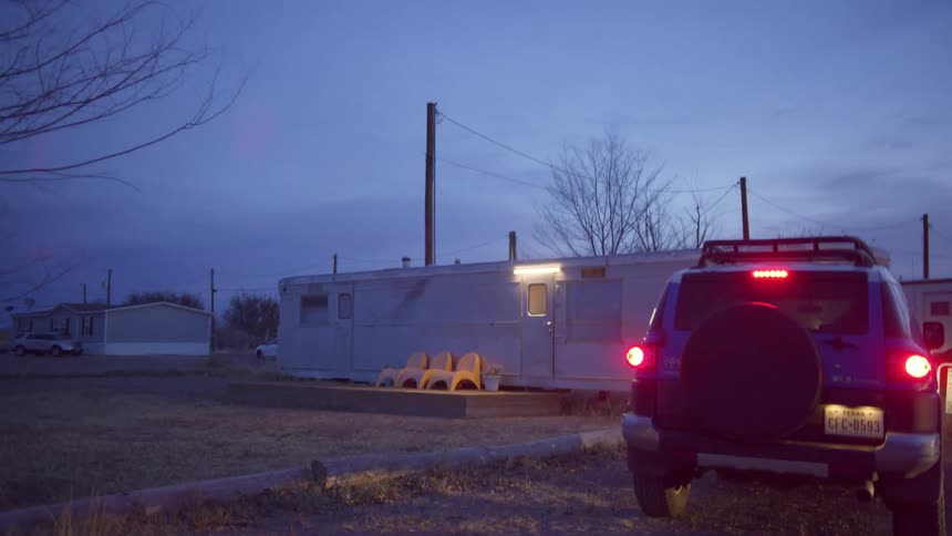 A blue suv approaches the house at night