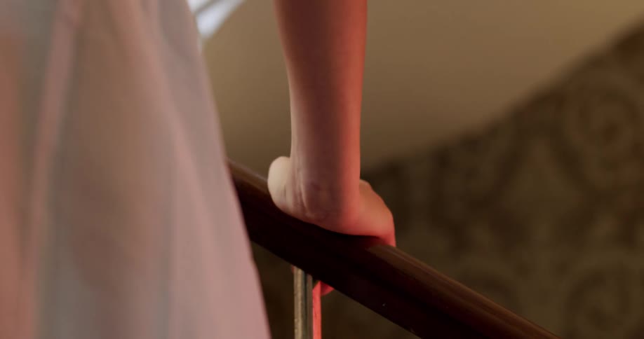 A woman is touching the staircase railing